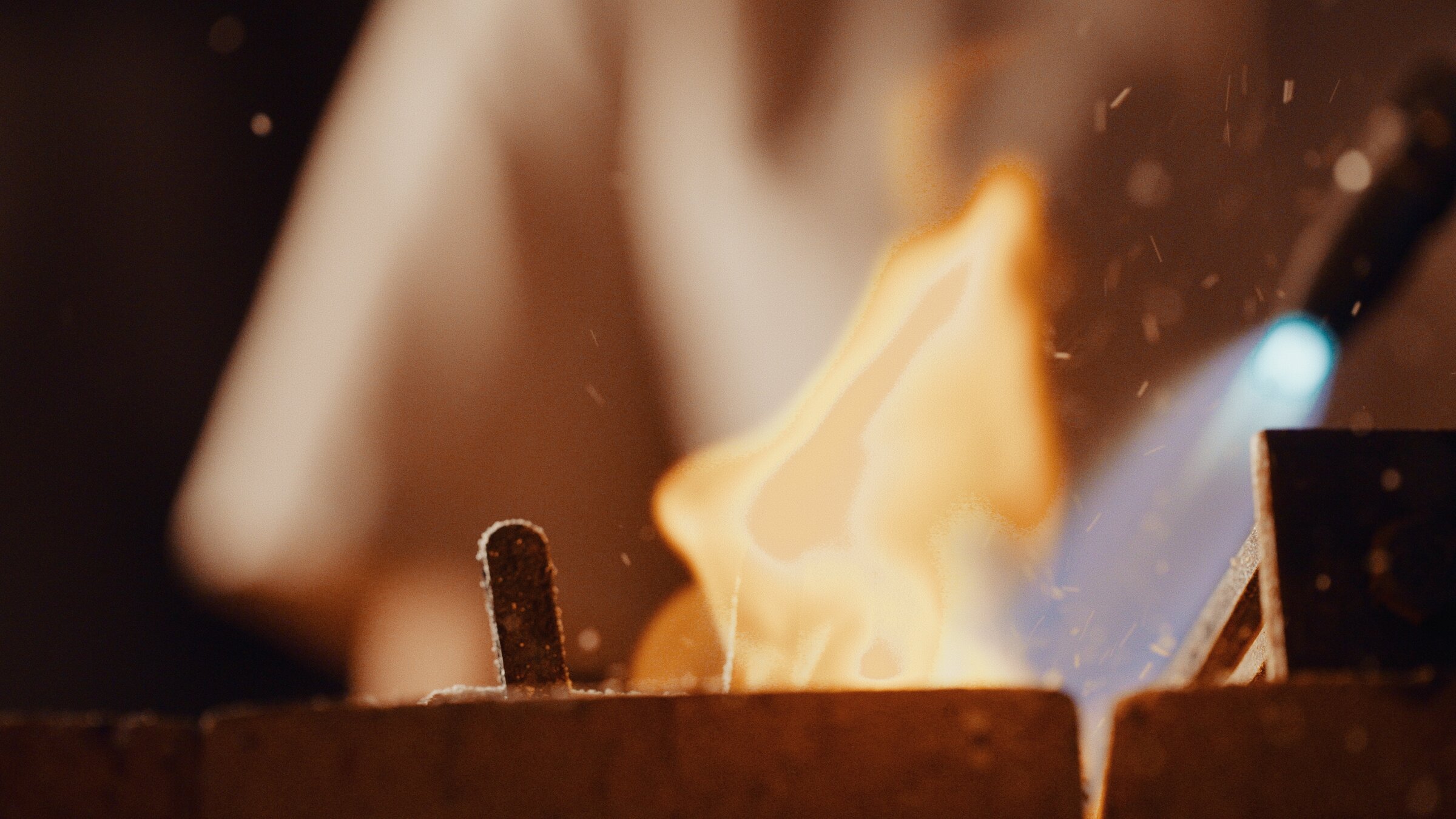 Jeweller at the bench, tools and gold rings in view