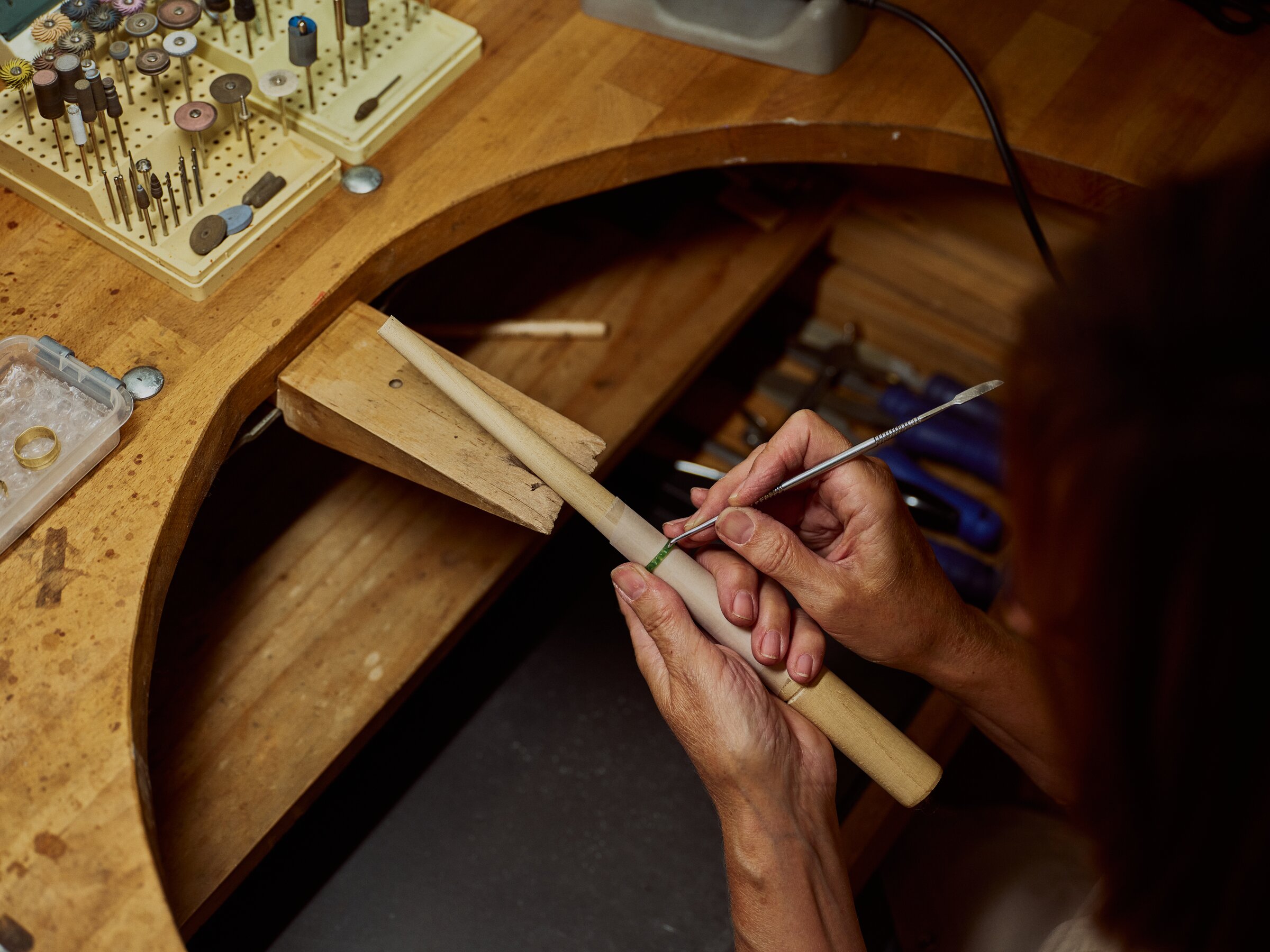 Setting a ring shank in a wooden clamp, fine tool in hand
