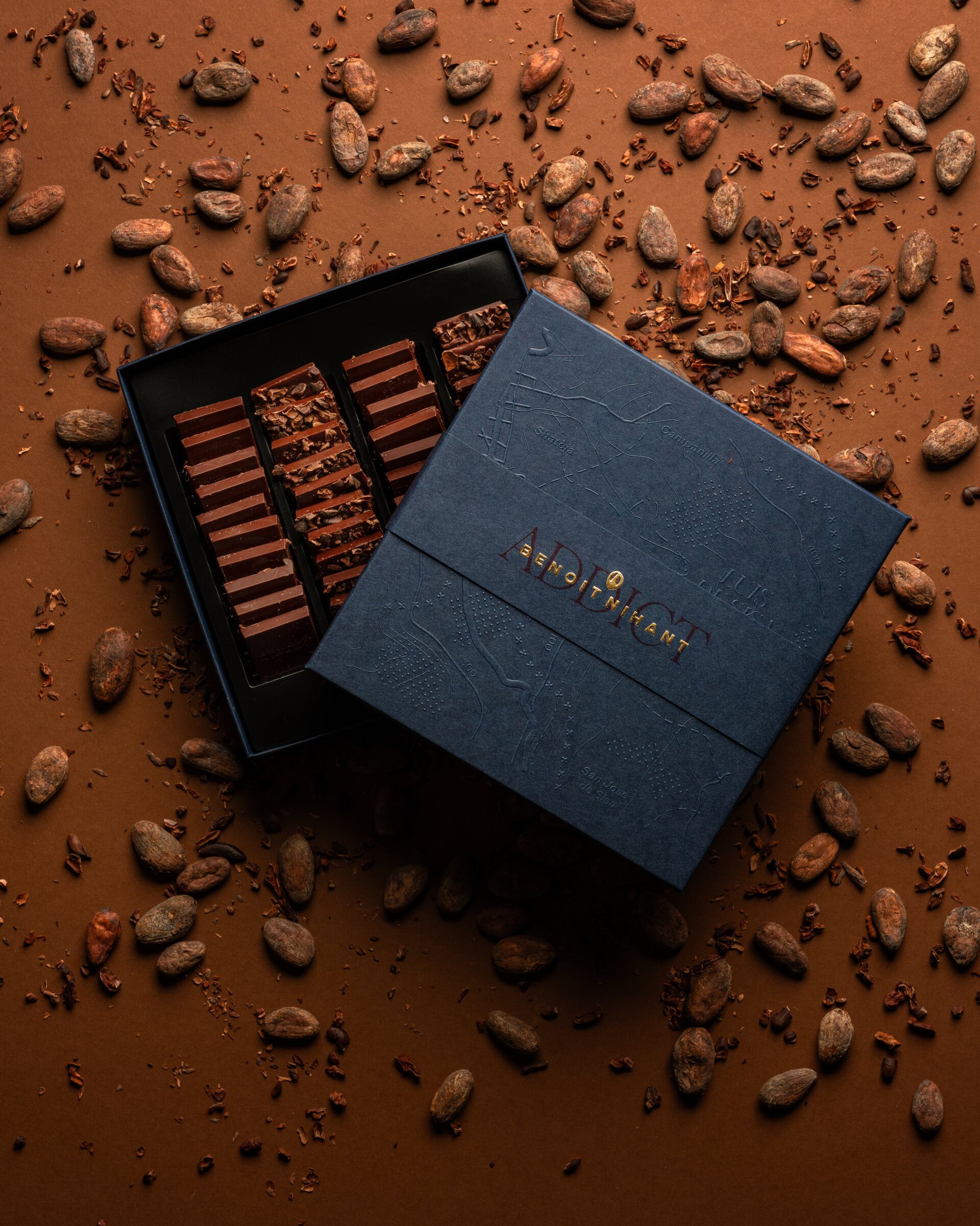 Benoît Nihant 'Addict' chocolate box open, surrounded by cocoa beans
