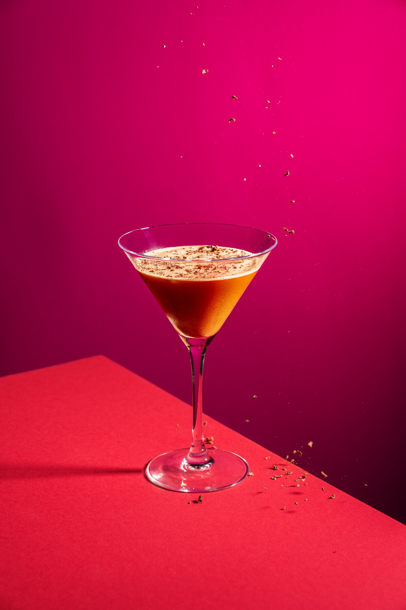 Espresso martini with coffee garnish, magenta backdrop
