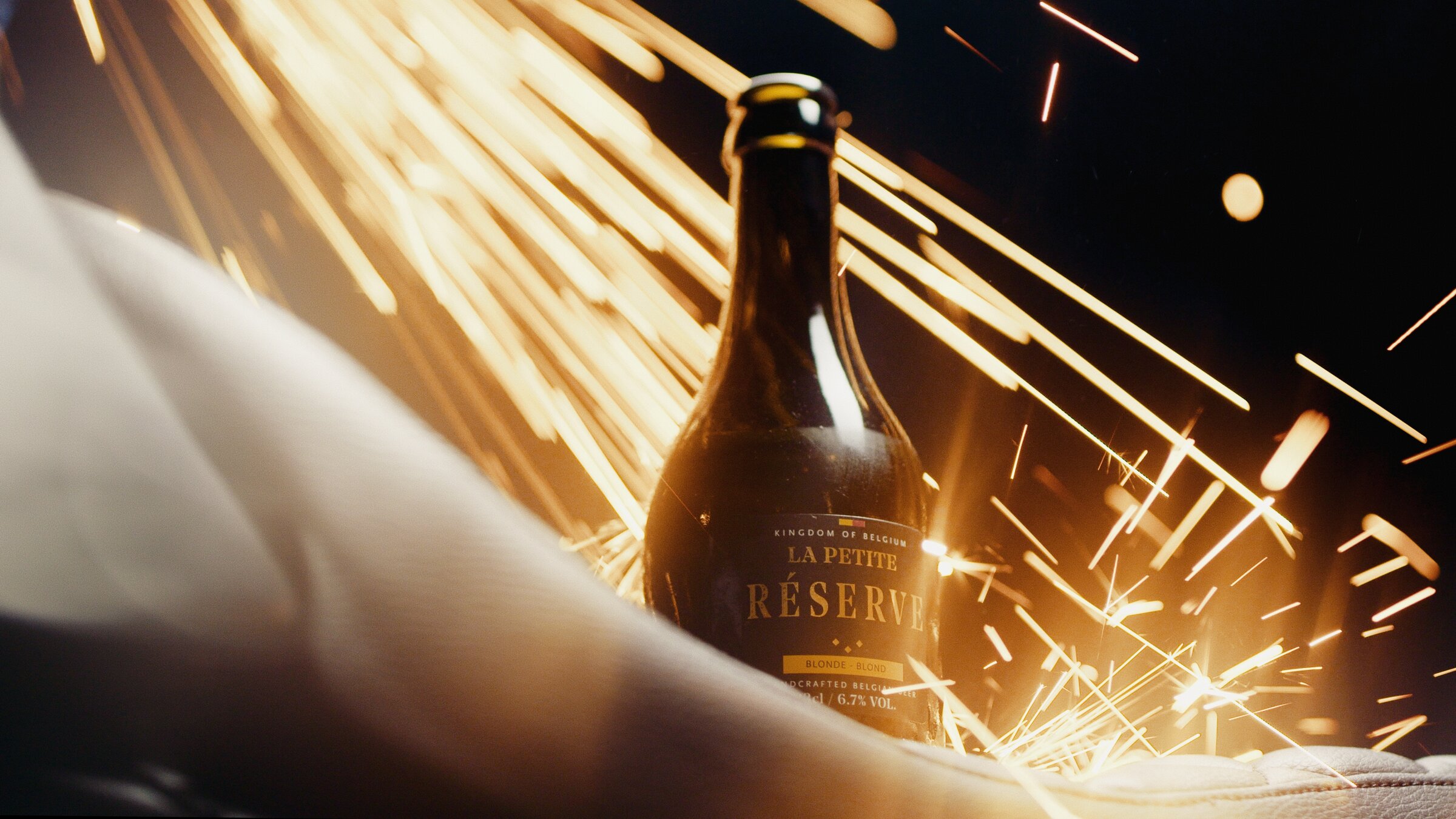 La Petite Réserve Blonde beer bottle, sparks in a workshop