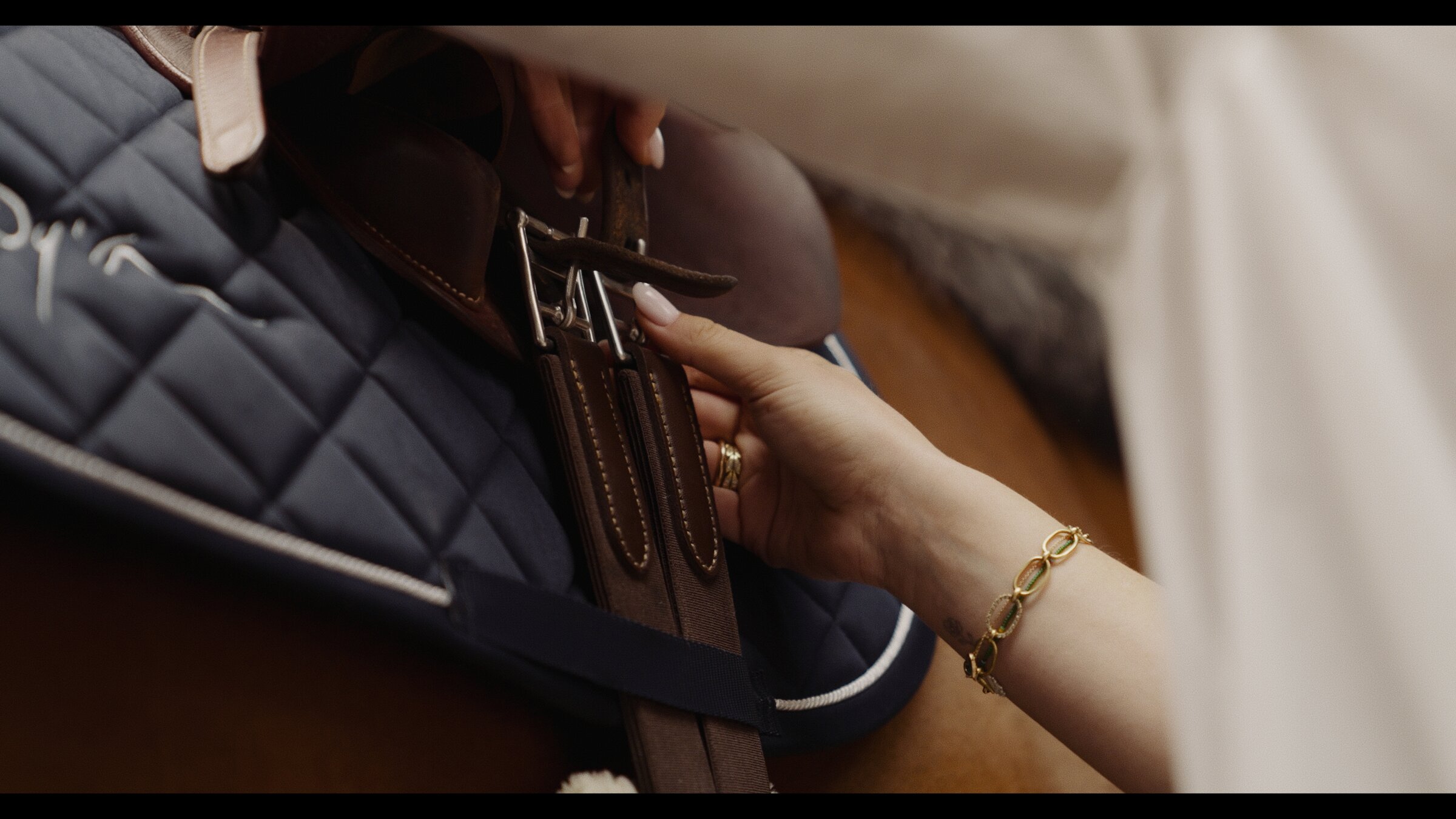 Hand adjusting the girth, fine jewellery detail