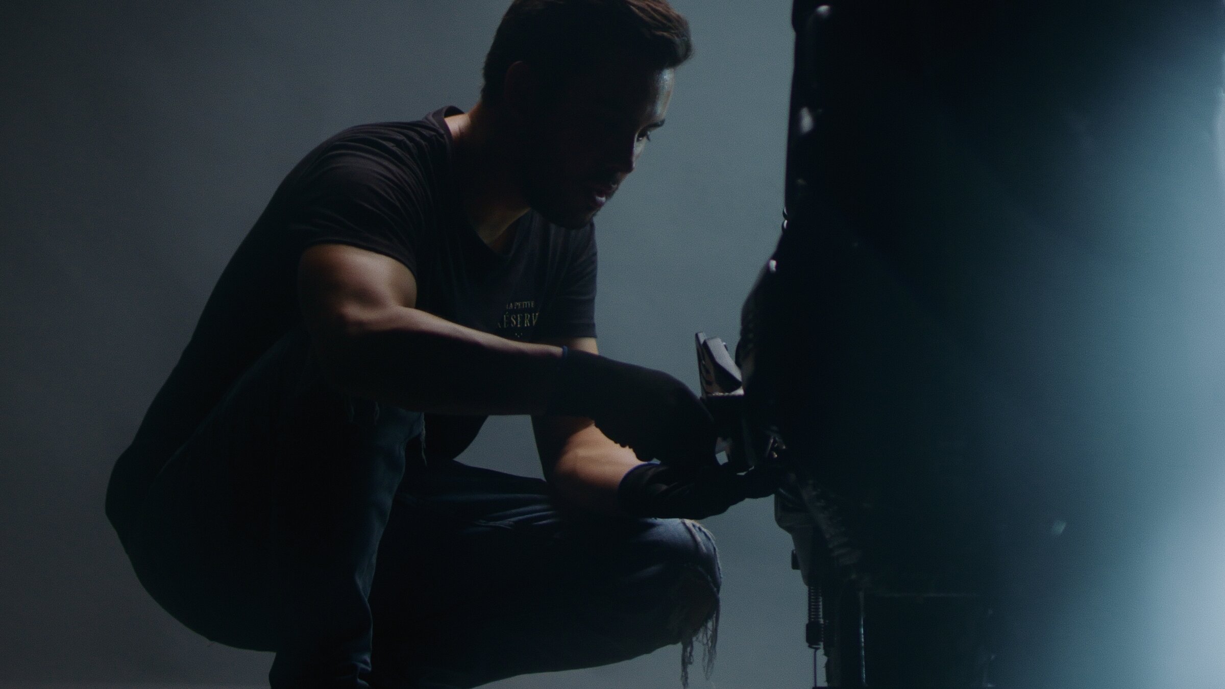 Mechanic crouched at work on the motorcycle