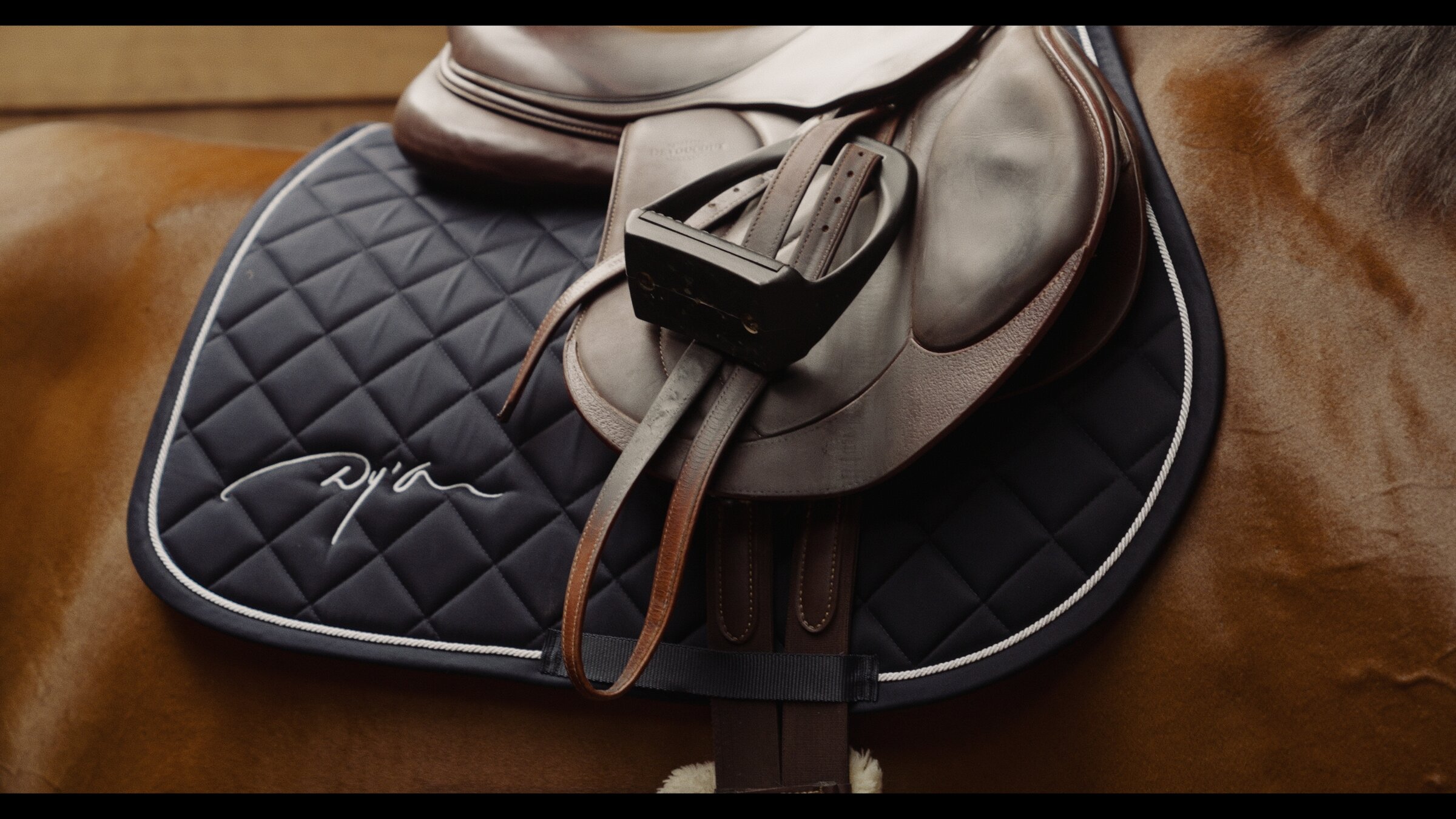 Saddle and stirrup detail, monogrammed saddle pad
