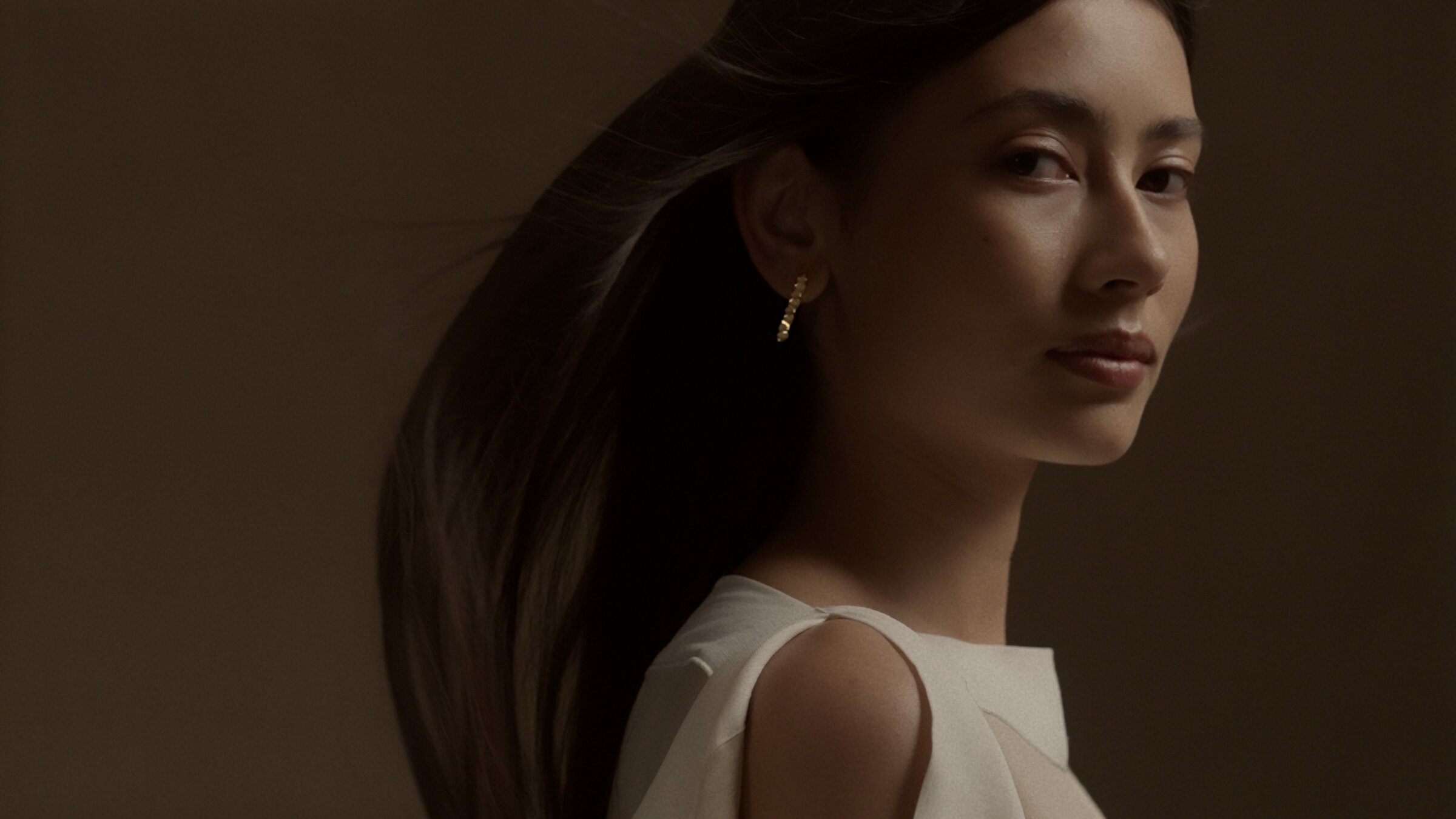 Model portrait wearing a gold hoop earring