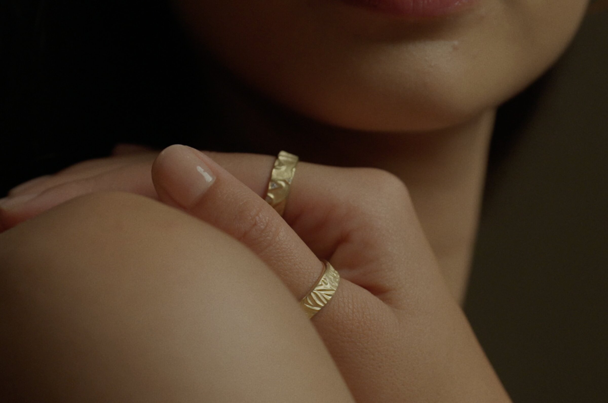 Two engraved gold rings, hand detail