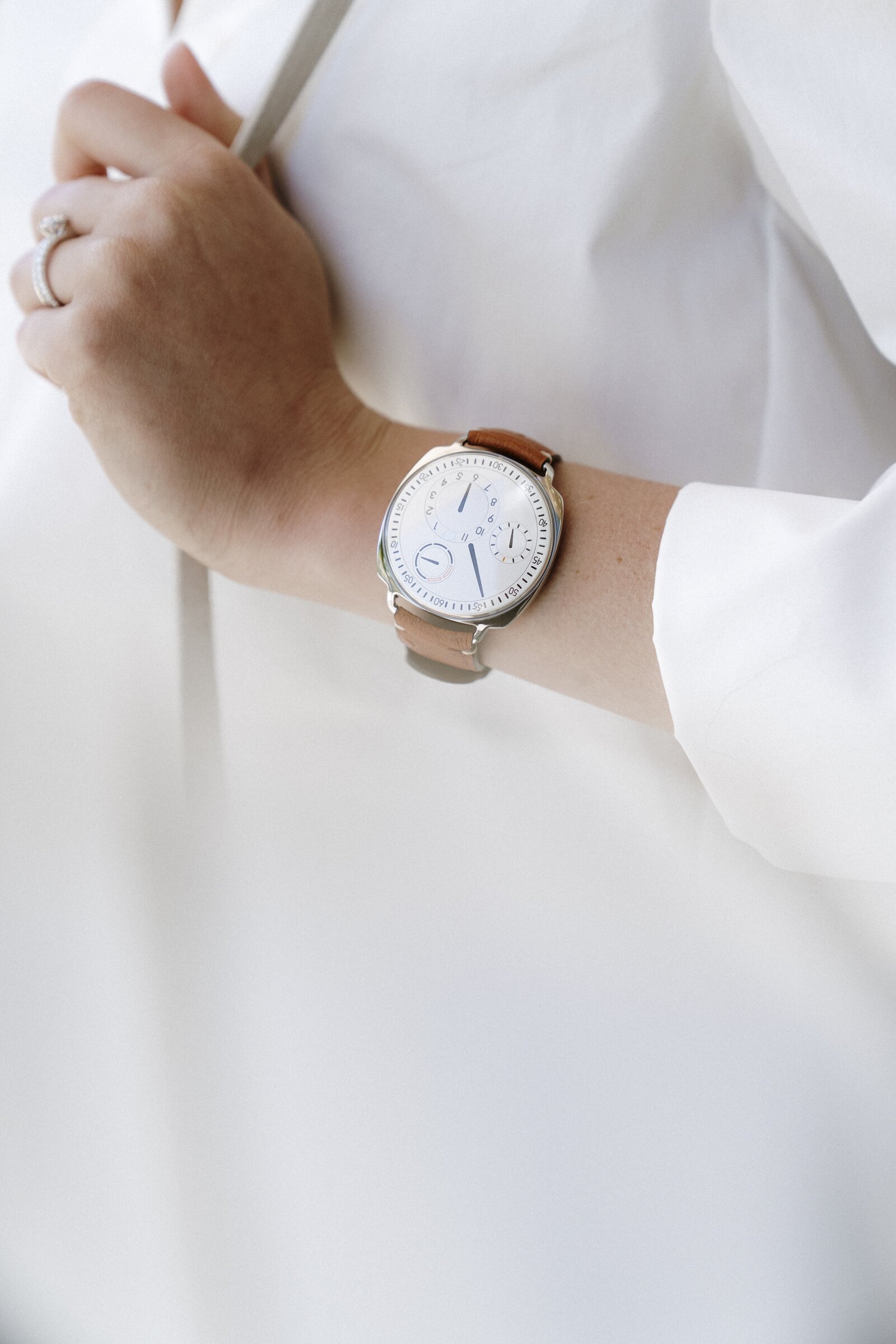 Watch with rotating dial display on a tan leather strap