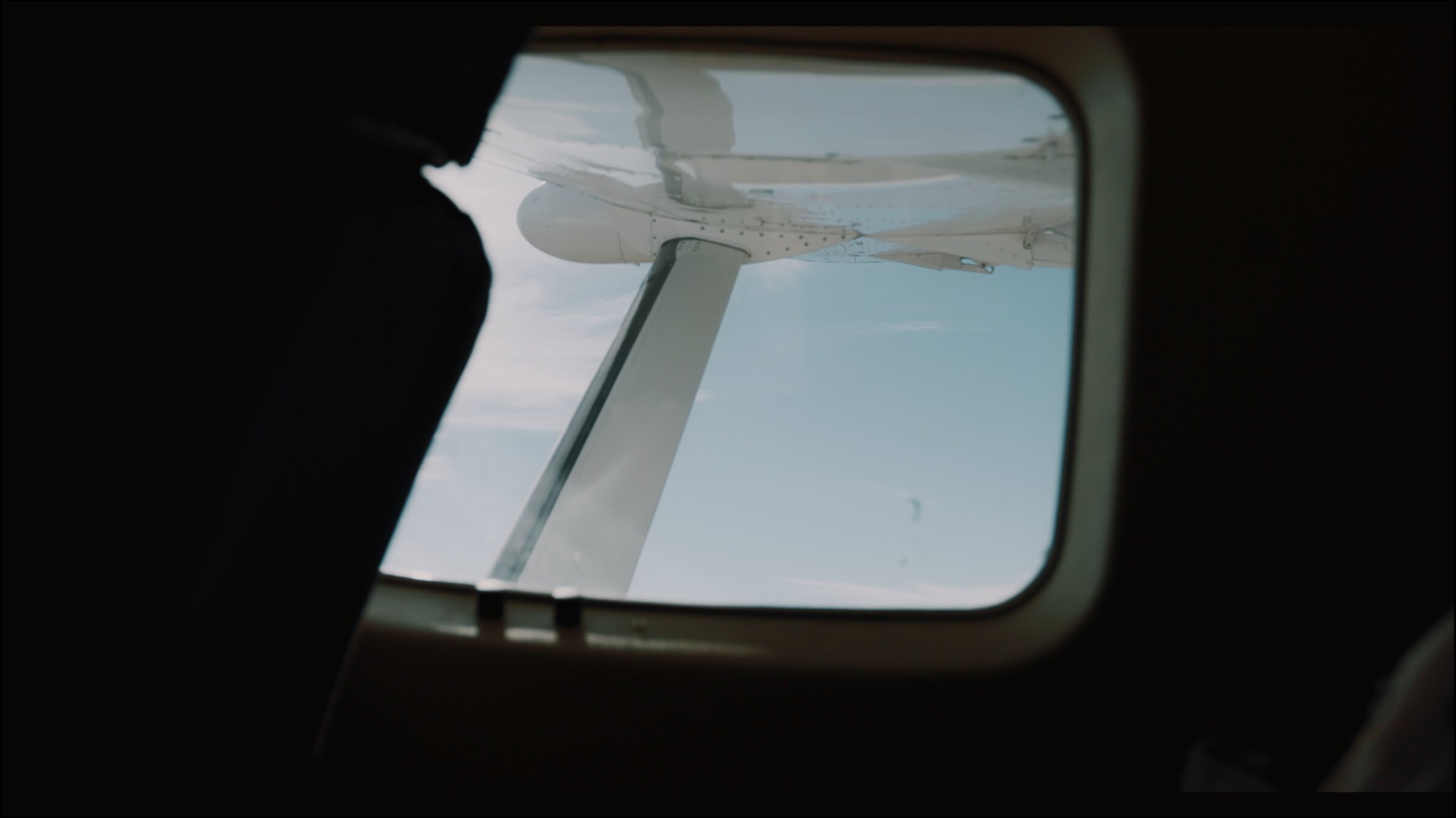 Bush plane wing seen through the window, mid-flight