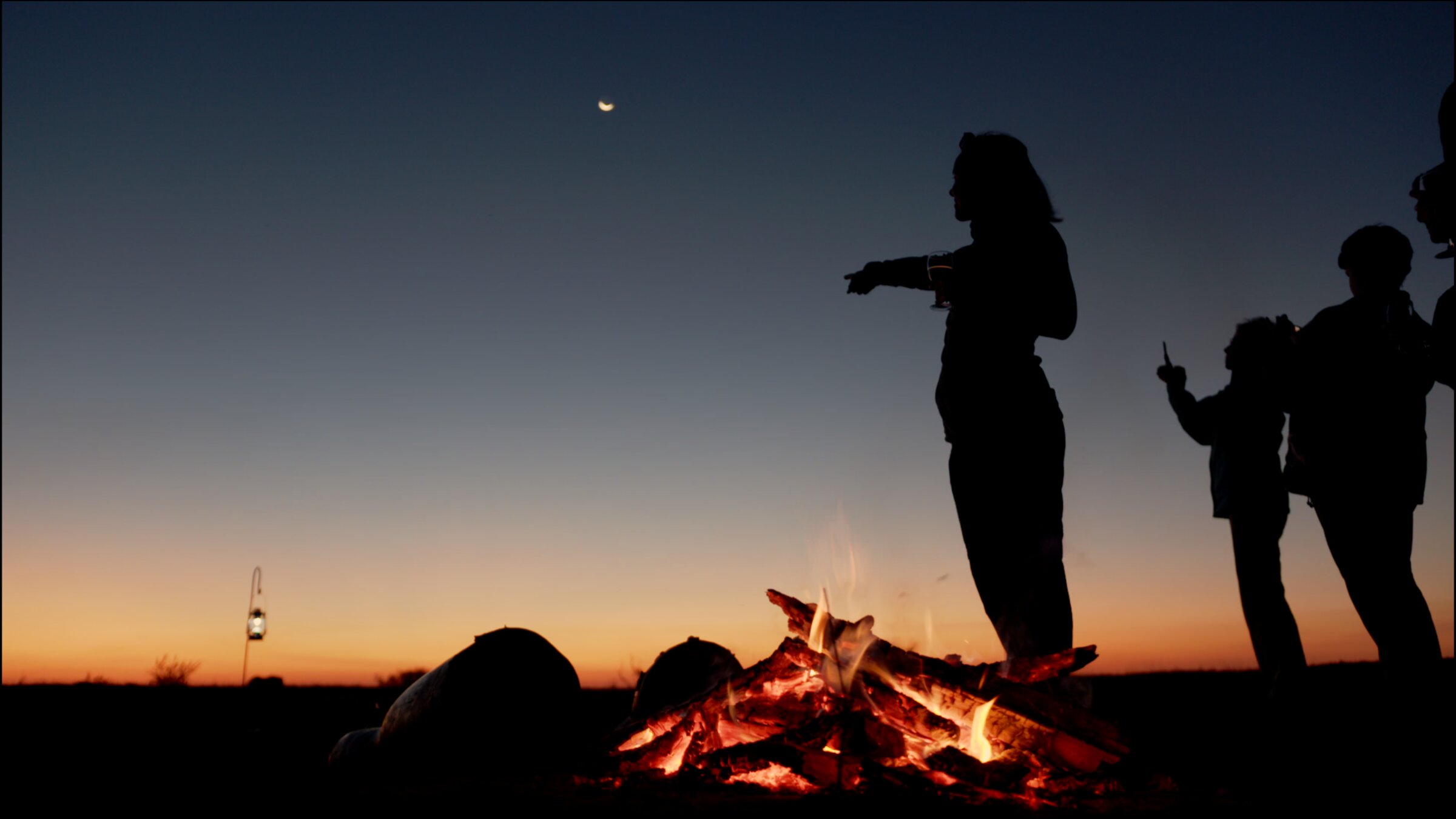 Campfire at dusk, silhouettes