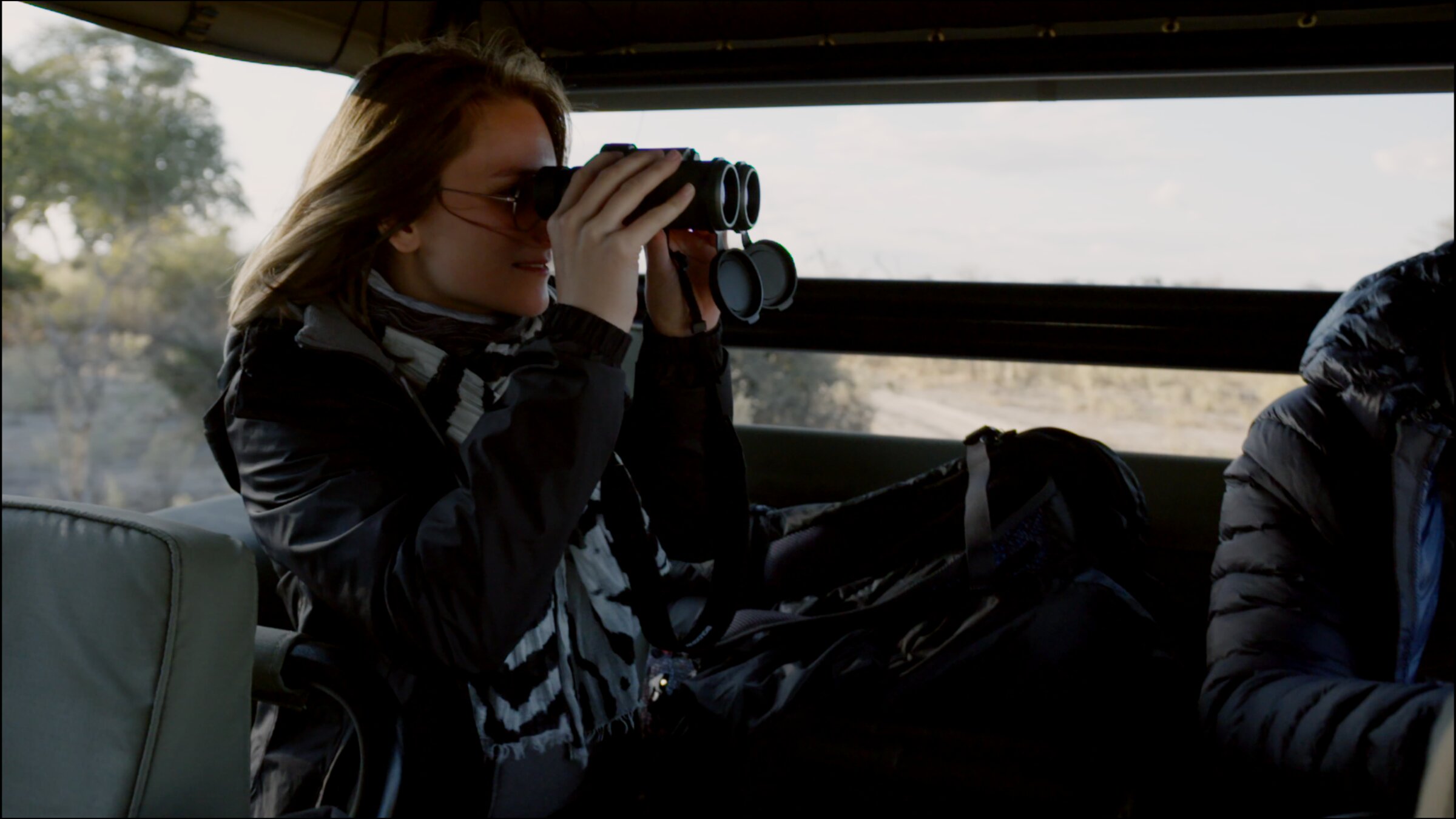 Guest with binoculars on a game drive